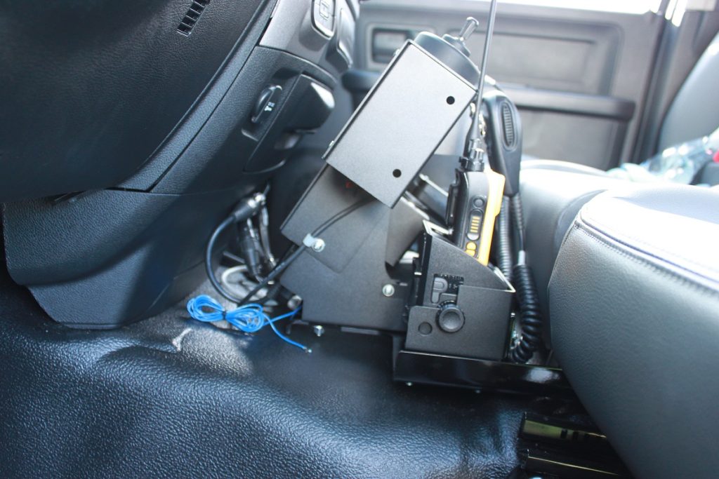 Radio communication equipment mounted between the driver's seat and console inside a vehicle.