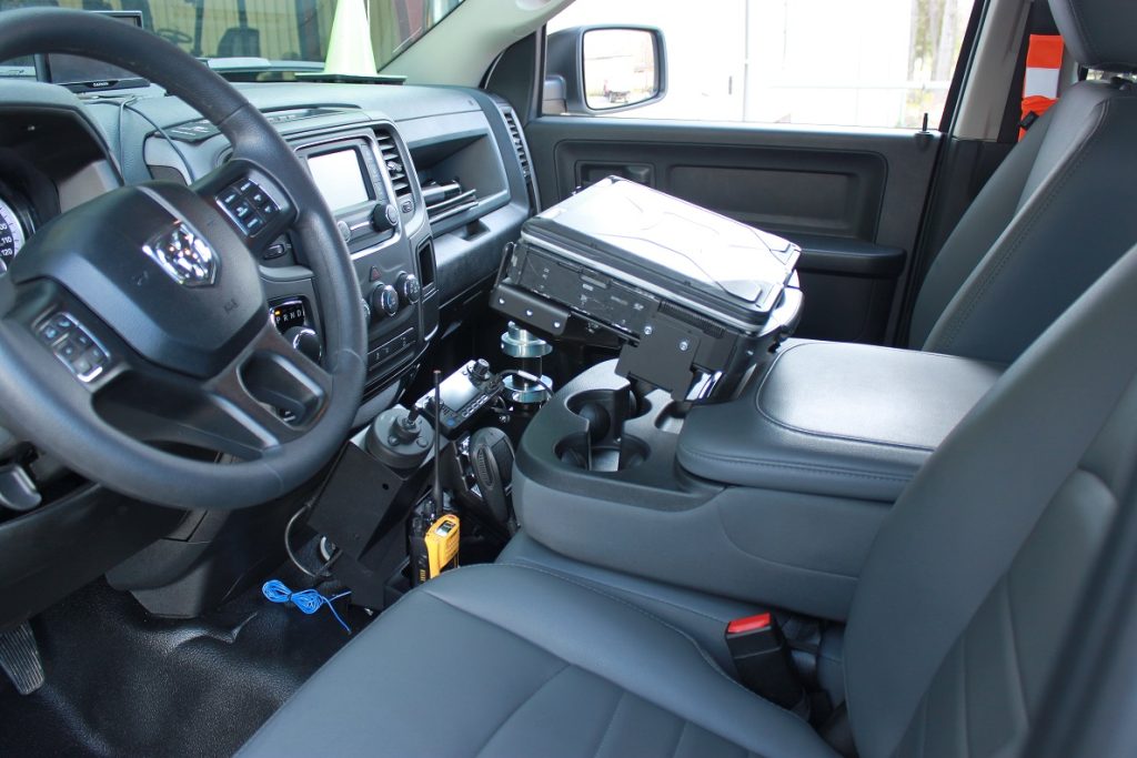 View of a vehicle interior with specialized equipment mounted between the driver and passenger seats.